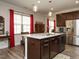 Gourmet kitchen island with dark wood cabinets, stainless steel appliances, and stylish pendant lighting at 107 Canary Ct, Raleigh, NC 27610