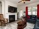 Inviting living room featuring a fireplace, a ceiling fan, and comfortable leather sofas at 107 Canary Ct, Raleigh, NC 27610