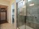 Modern tiled shower with glass door, built-in seat, and safety bars for accessibility and comfort at 107 Canary Ct, Raleigh, NC 27610