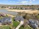 Aerial view of a landscaped house with a lake and golf course in the background at 107 Zaharis Cv, Raleigh, NC 27603