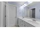 Bright bathroom featuring double sinks, a large mirror, and clean, white cabinets and doors at 107 Zaharis Cv, Raleigh, NC 27603