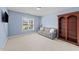 Comfortable light blue bedroom with a cozy sofa, large bookcase, and natural light at 107 Zaharis Cv, Raleigh, NC 27603