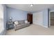 Serene light blue bedroom featuring a sofa, bookshelf, and ample natural light from the window at 107 Zaharis Cv, Raleigh, NC 27603