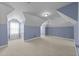 Spacious bonus room with blue accent walls and neutral carpeting at 107 Zaharis Cv, Raleigh, NC 27603