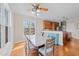 Charming dining room with hardwood floors, a ceiling fan, and views into the modern kitchen at 107 Zaharis Cv, Raleigh, NC 27603