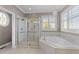 Spa-like bathroom with soaking tub, glass shower and natural light from shuttered windows at 107 Zaharis Cv, Raleigh, NC 27603