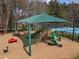 Community playground featuring a slide, play car, and a covered seating area adjacent to the tennis court at 107 Zaharis Cv, Raleigh, NC 27603