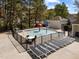 Community splash pad with sun loungers, umbrellas, and a gated fence at 107 Zaharis Cv, Raleigh, NC 27603