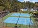 Aerial view of community tennis courts with green and blue surface in a wooded area at 107 Zaharis Cv, Raleigh, NC 27603