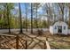 Backyard featuring a wooden deck, white fence, a shed, and mature trees providing privacy at 1108 Medlin Dr, Cary, NC 27511