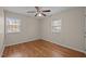 Bedroom featuring hardwood floors, a ceiling fan, and natural light from the two windows at 1108 Medlin Dr, Cary, NC 27511