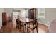 Dining room with wood floors, large wooden table with 6 chairs, and a large hutch with glass doors at 1108 Medlin Dr, Cary, NC 27511