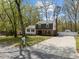 Two-story home with a brick facade, siding, dormer windows, landscaping, long driveway, and mailbox view from the street at 1108 Medlin Dr, Cary, NC 27511