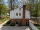View of back exterior of home with a brick chimney, a patio, and a white fence at 1108 Medlin Dr, Cary, NC 27511