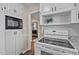 Bright kitchen featuring white appliances, white cabinets, and a view to the next room at 1108 Medlin Dr, Cary, NC 27511
