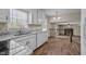 Bright kitchen with white cabinets, granite countertops, a stainless steel sink, and hardwood floors with a view into living room at 1108 Medlin Dr, Cary, NC 27511