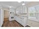 White kitchen featuring granite countertops, white cabinets and hardwood style floors at 1108 Medlin Dr, Cary, NC 27511