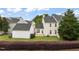 A serene backyard with a lush green lawn, a privacy hedge, and a detached garage at 1116 Silky Dogwood Trl, Apex, NC 27502