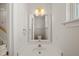 Bright powder room featuring a white vanity with a square mirror and decorative sconce lighting at 1116 Silky Dogwood Trl, Apex, NC 27502