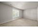 Neutral bedroom featuring a large window with blinds and neutral walls with white trim and carpet at 1116 Silky Dogwood Trl, Apex, NC 27502
