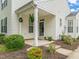 Inviting front porch with covered entrance, lush landscaping, and classic white siding at 1116 Silky Dogwood Trl, Apex, NC 27502