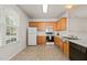 Efficient kitchen features tile floors, white appliances, and wood cabinets for a functional cooking space at 1116 Silky Dogwood Trl, Apex, NC 27502