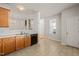 Open kitchen with tile floors, wooden cabinets, and black dishwasher leads to dining area and staircase at 1116 Silky Dogwood Trl, Apex, NC 27502
