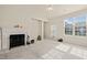 Bright living room with fireplace, neutral walls, carpet, and natural light from the windows and glass door at 1116 Silky Dogwood Trl, Apex, NC 27502