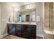 Bathroom with double vanity, large mirror, wood-look floors, and a glass-enclosed tile shower at 112 Willow Grove Ln, Fuquay Varina, NC 27526