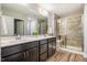 Elegant bathroom featuring a double vanity, large mirror, and a glass-enclosed shower with a built-in bench at 112 Willow Grove Ln, Fuquay Varina, NC 27526
