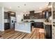 Spacious kitchen with dark cabinetry, a central island, stainless steel appliances, and hardwood floors at 112 Willow Grove Ln, Fuquay Varina, NC 27526