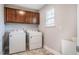 Laundry room including a washer, dryer, sink, storage cabinets, and tile floor at 112 Willow Grove Ln, Fuquay Varina, NC 27526