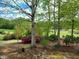 Inviting backyard with mature trees and flowering bushes overlooking a golf course at 117 Linwood Ln, Clayton, NC 27527