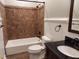 Bathroom with a white vanity, dark counter, and a fully tiled shower and bath at 117 Linwood Ln, Clayton, NC 27527