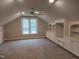 This carpeted bonus room features built-in shelves, a ceiling fan, and a large window for natural light at 117 Linwood Ln, Clayton, NC 27527