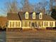 Beautiful white home featuring dormer windows and dark shutters, nestled among mature trees at 117 Linwood Ln, Clayton, NC 27527