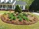 Beautiful landscaping with a birdbath, flowers, and shrubbery in the front yard at 117 Linwood Ln, Clayton, NC 27527