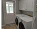 Bright laundry room with white cabinetry, washer, dryer, and access to exterior at 117 Linwood Ln, Clayton, NC 27527