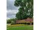 Entrance sign to Riverwood Golf Club featuring a brick facade and vibrant flower beds at 117 Linwood Ln, Clayton, NC 27527