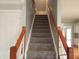 Carpeted staircase leading to the upper level with wooden rails and view of the entry at 117 Linwood Ln, Clayton, NC 27527