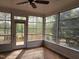 Bright sun room with many windows overlooking a wooden deck and mature trees at 117 Linwood Ln, Clayton, NC 27527