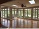 Open sunroom featuring hardwood floors, a ceiling fan, and large windows providing natural light at 117 Linwood Ln, Clayton, NC 27527