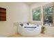 Luxurious bathroom features a jacuzzi tub, tile surround, and natural light at 1217 Mauldin Rd, Wake Forest, NC 27587