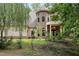 Charming stone and siding home featuring a turret, covered entrance, and lush landscaping at 1217 Mauldin Rd, Wake Forest, NC 27587