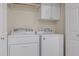 Bright laundry room with Whirlpool washer and dryer, plus storage cabinets for convenience at 1220 Manassas Ct Ct # E, Raleigh, NC 27609