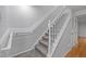 Carpeted staircase featuring a white railing and trim at 1220 Manassas Ct Ct # E, Raleigh, NC 27609