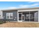 This house has a screened porch and grey siding in the backyard under a sunny blue sky at 1243 White Flint Cir, Durham, NC 27703