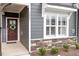 Close-up of a front door adorned with a wreath, complemented by a window and stone accents at 1243 White Flint Cir, Durham, NC 27703