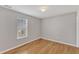 Empty bedroom with hardwood floors, neutral walls, and a window at 125 Hidden Springs Dr, Durham, NC 27703