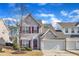 Charming two-story home with red shutters, attached garage and landscaped front yard, under blue skies at 125 Hidden Springs Dr, Durham, NC 27703